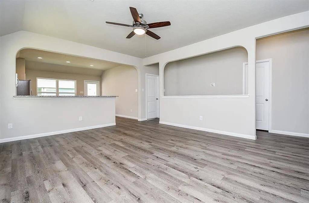 Spacious living area with modern lighting and elegant laminate flooring
