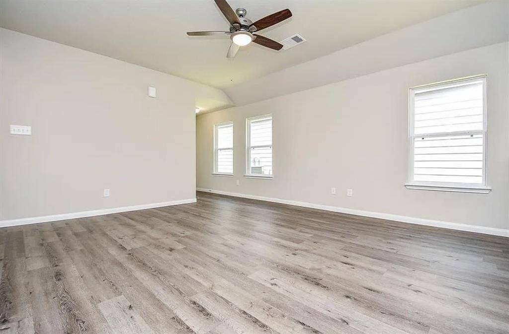 Another view of the well-ventilated living room offering comfort and natural sunlight.