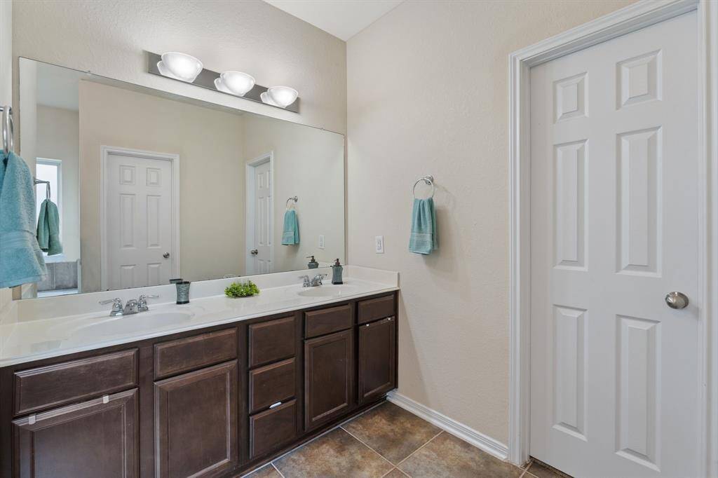 Double sinks and just through door is a large walk-in closet.