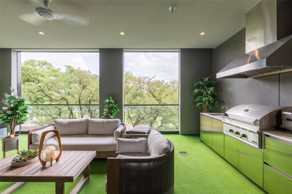 Beautifully designed enclosed 390 SF loggia equipped with an outdoor kitchen featuring a built-in grill, ample counter space, and a cozy area for dining and entertaining.