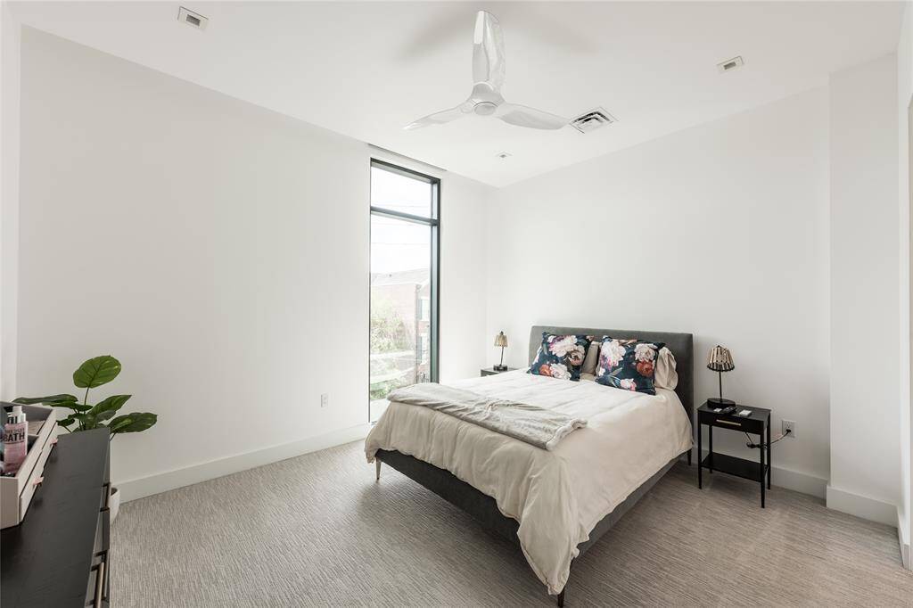 Spacious secondary ensuite with floor-to-ceiling windows, remote-controlled blackout shades, and a large walk-in closet, offering both privacy and natural light in an elegant setting.