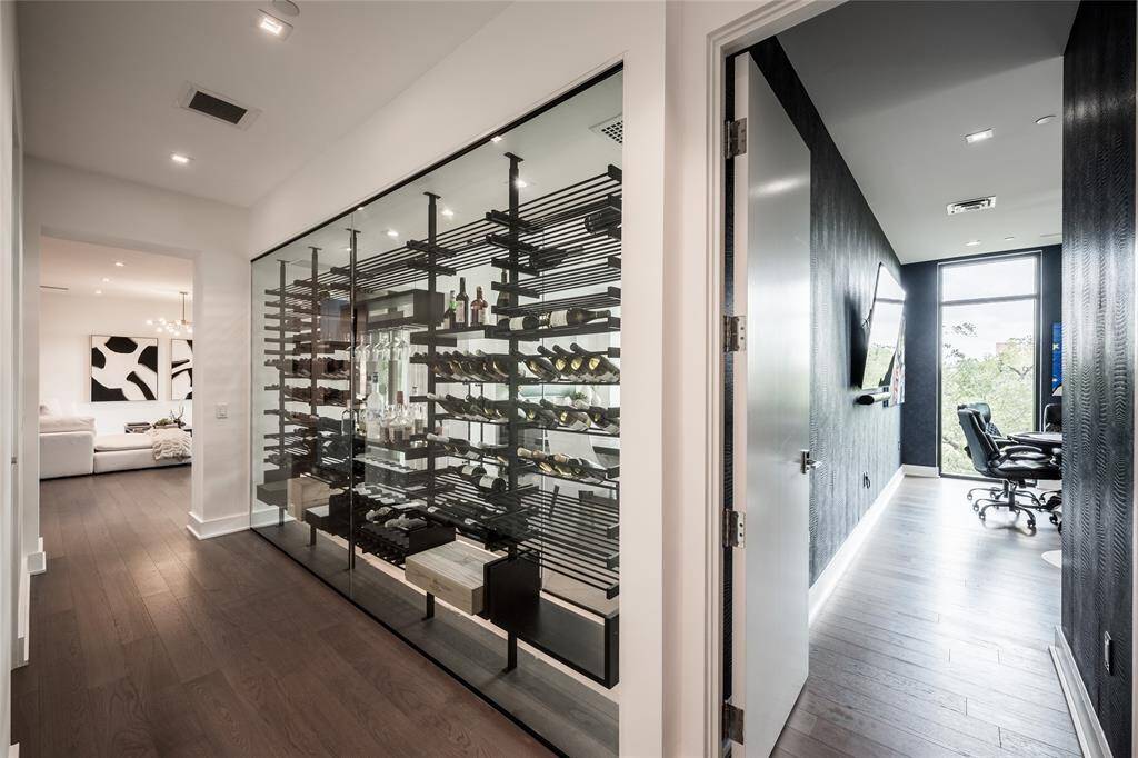 A wall was removed to make way for a custom, temperature-controlled glass wine cellar—an architectural statement piece with a 500-bottle capacity, blending function with contemporary design.