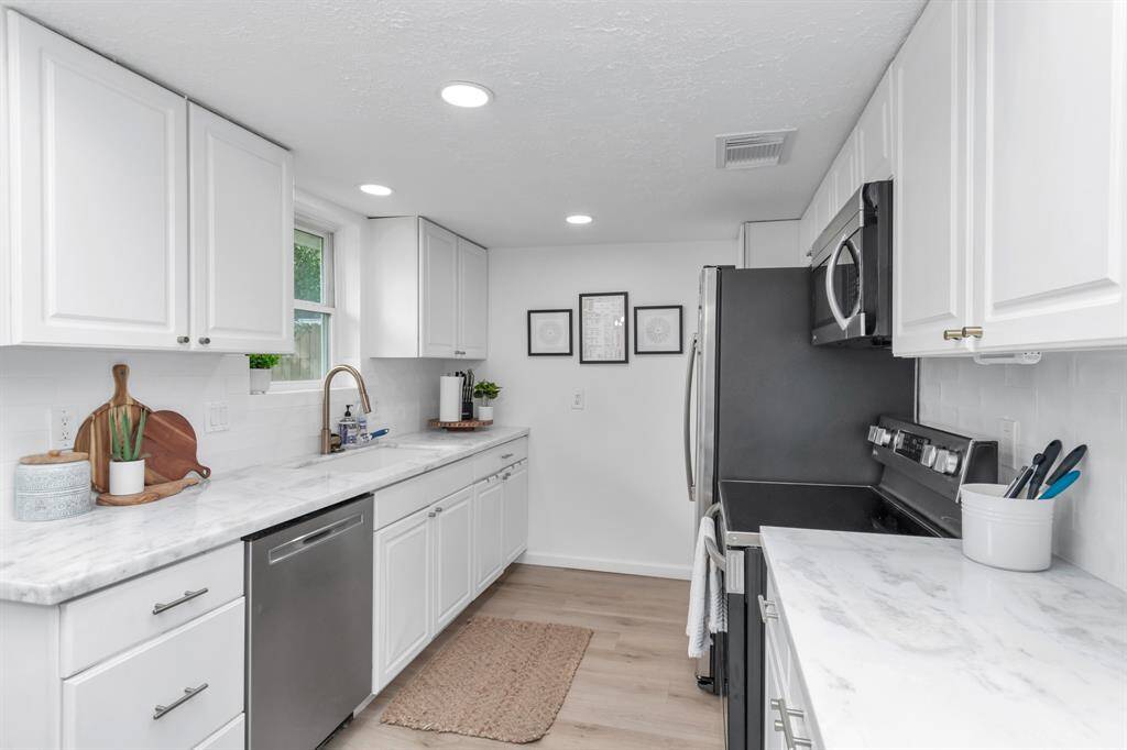 The updated kitchen features stunning natural stone dolomite countertops and stainless steel appliances, making it a chef’s dream.