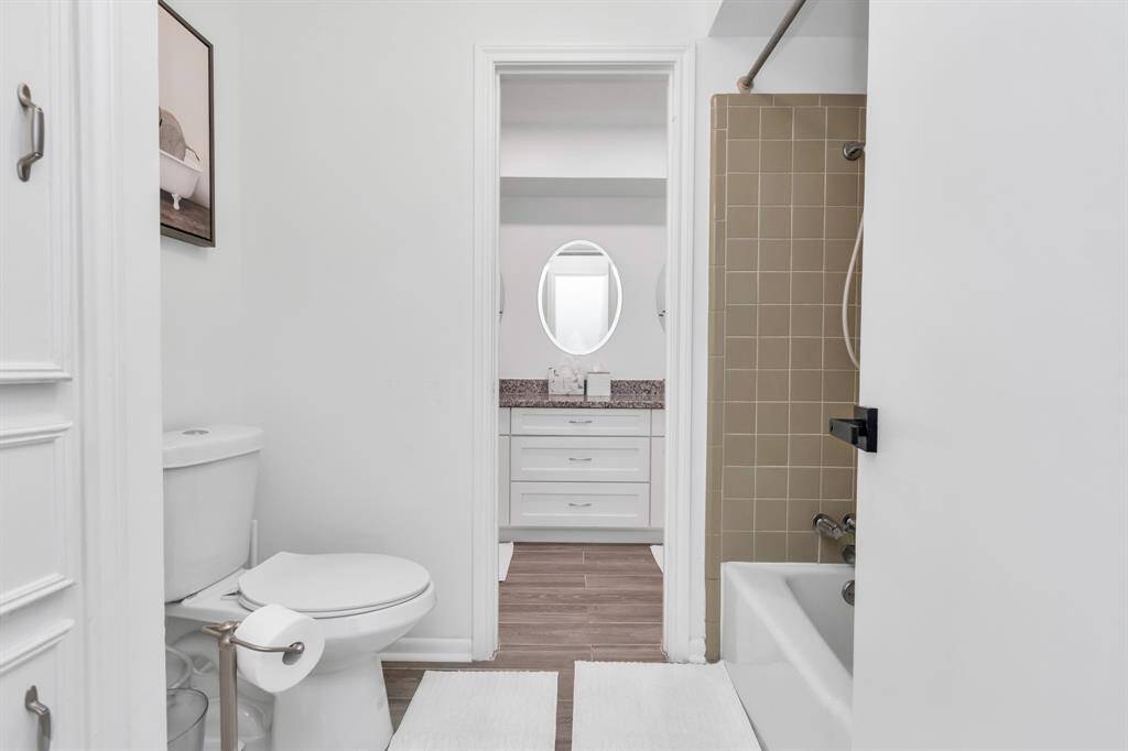 This shared Jack and Jill bathroom features a dual-sink vanity, providing plenty of space for both bedrooms. The tub-shower combo adds flexibility for both quick showers and relaxing baths, making it ideal for family living or shared spaces.