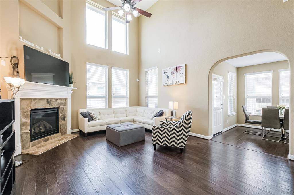 Light filled great room has double height ceiling and a fireplace