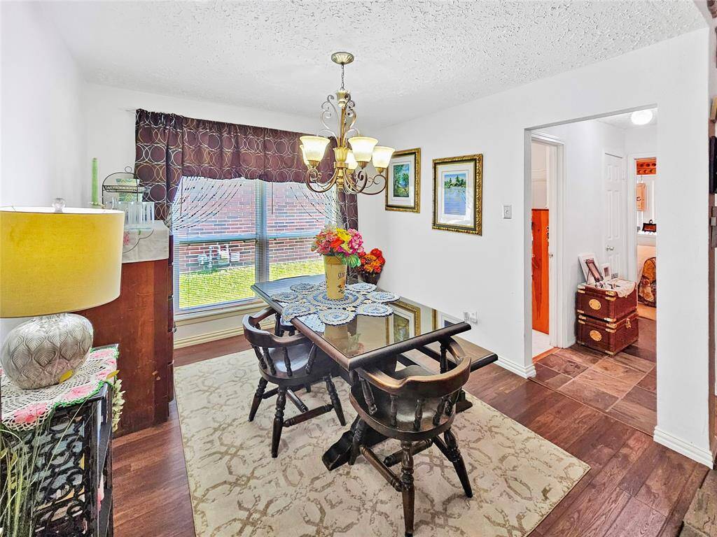 Dining room floors have laminate wood and lead to a hallway bathroom and two bedrooms.