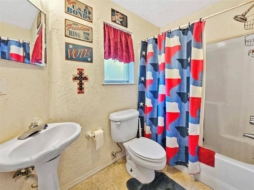 Hallway bathroom has a pedestal sink and tub/shower combo.