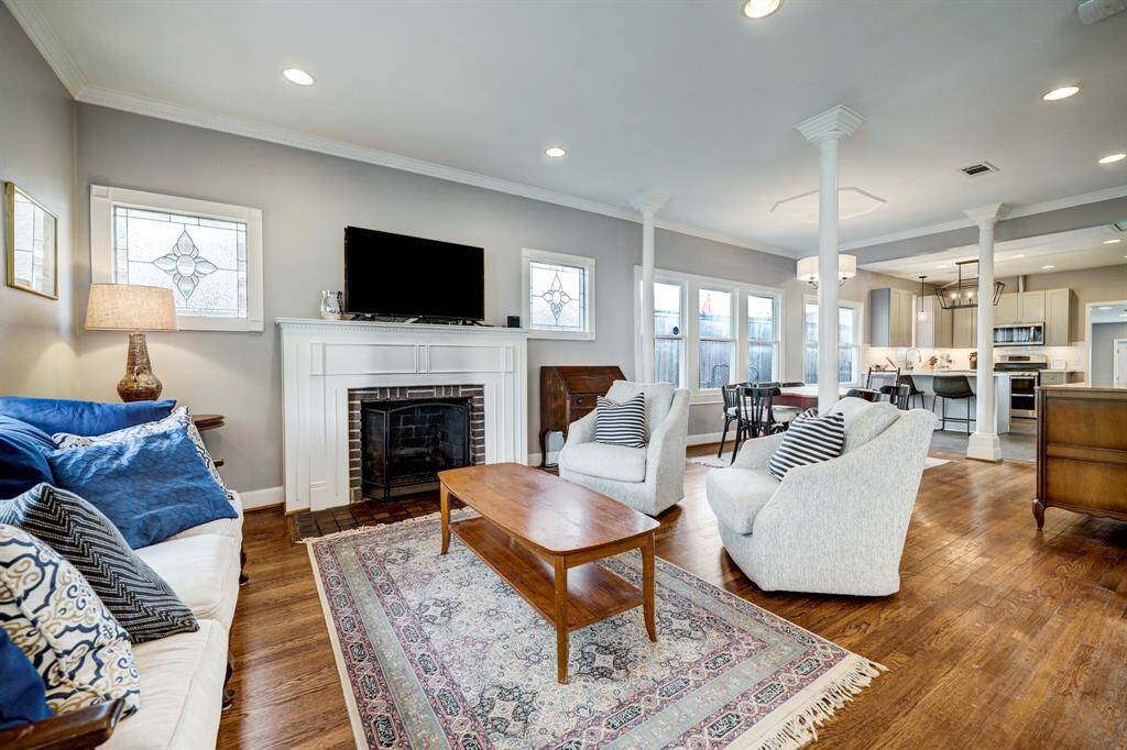 Another view of the living room with gas log fireplace, open to the dining room and kitchen. *Photos are from a previous listing and may not reflect the property's current condition.