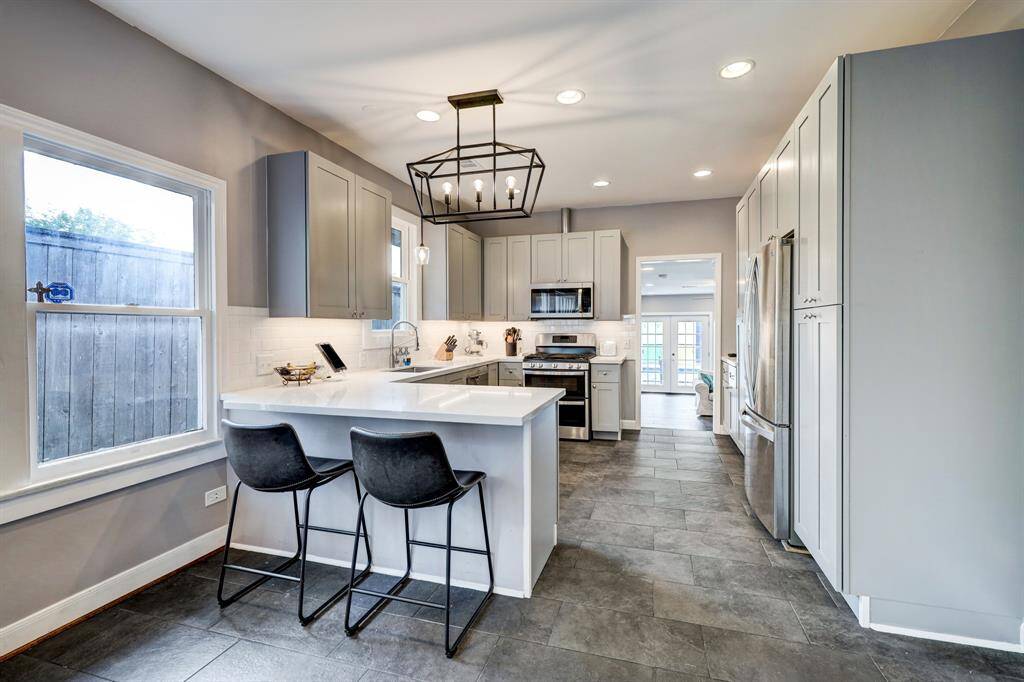 Renovated kitchen with breakfast bar, quartz countertops, and SS appliances. *Photos are from a previous listing and may not reflect the property's current condition.