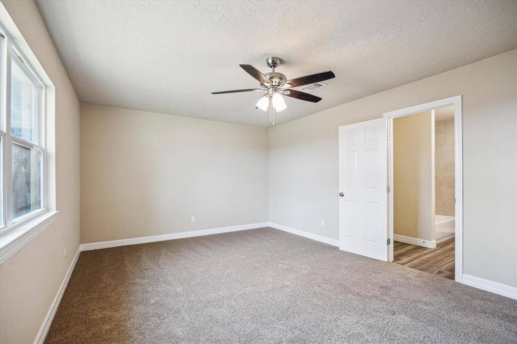 Spacious primary bedroom with direct access to a private ensuite bath.