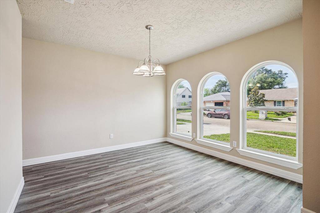 Bright and inviting dining room with elegant arched windows and modern flooring.