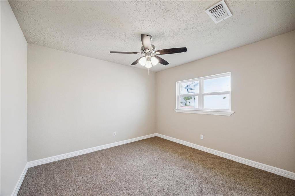 Cozy third bedroom with ample natural light and a spacious closet, perfect for family, guests or a home office.