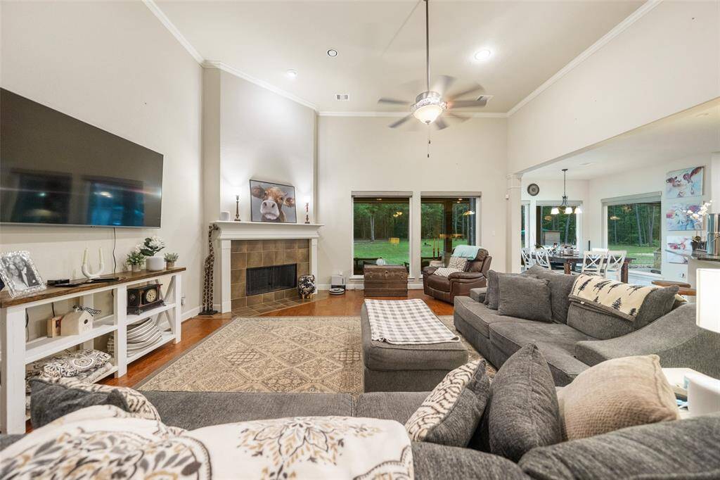 The spacious family room features a soaring ceiling with a cooling fan and recessed lights, gorgeous hardwood floors, and a cozy gas-log fireplace. It's the perfect for relaxing evenings or lively gatherings, all with tranquil views of the wooded backyard.