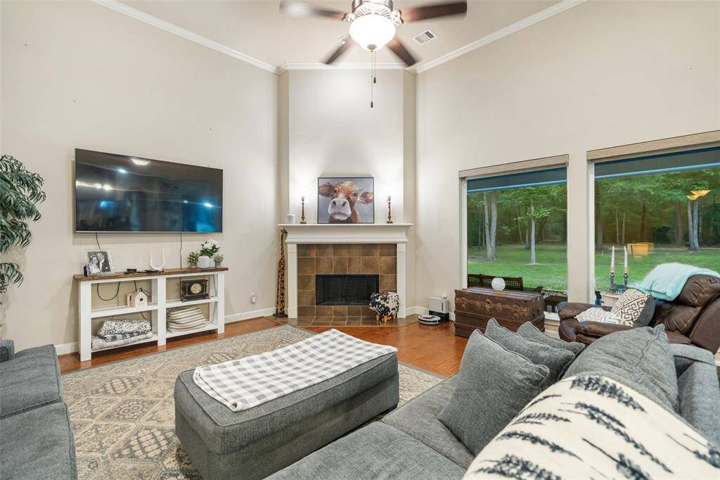 Relax by the cozy gas-log fireplace in this spacious family room, where soaring ceilings and rich hardwoods meet an open layout that flows seamlessly into the dining area, perfect for everyday living and entertaining.