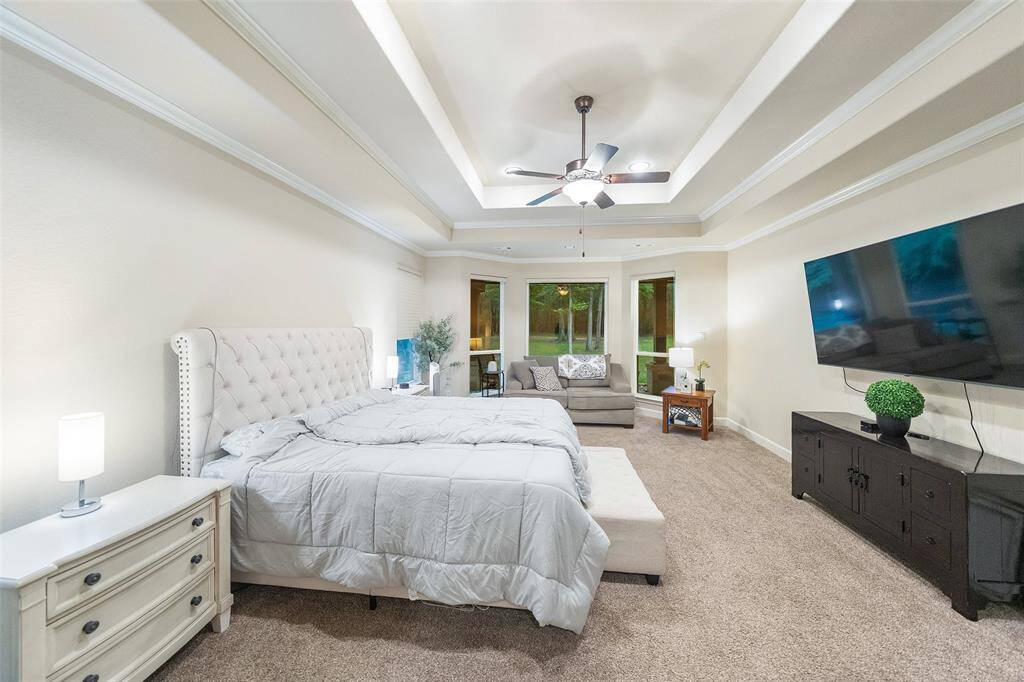 End your day in this serene primary suite featuring a raised tray ceiling, plush carpeting, and a cozy sitting area framed by bay windows with peaceful backyard views. The suite also includes two walk-in closets and a spacious ensuite bathroom, offering both comfort and convenience.