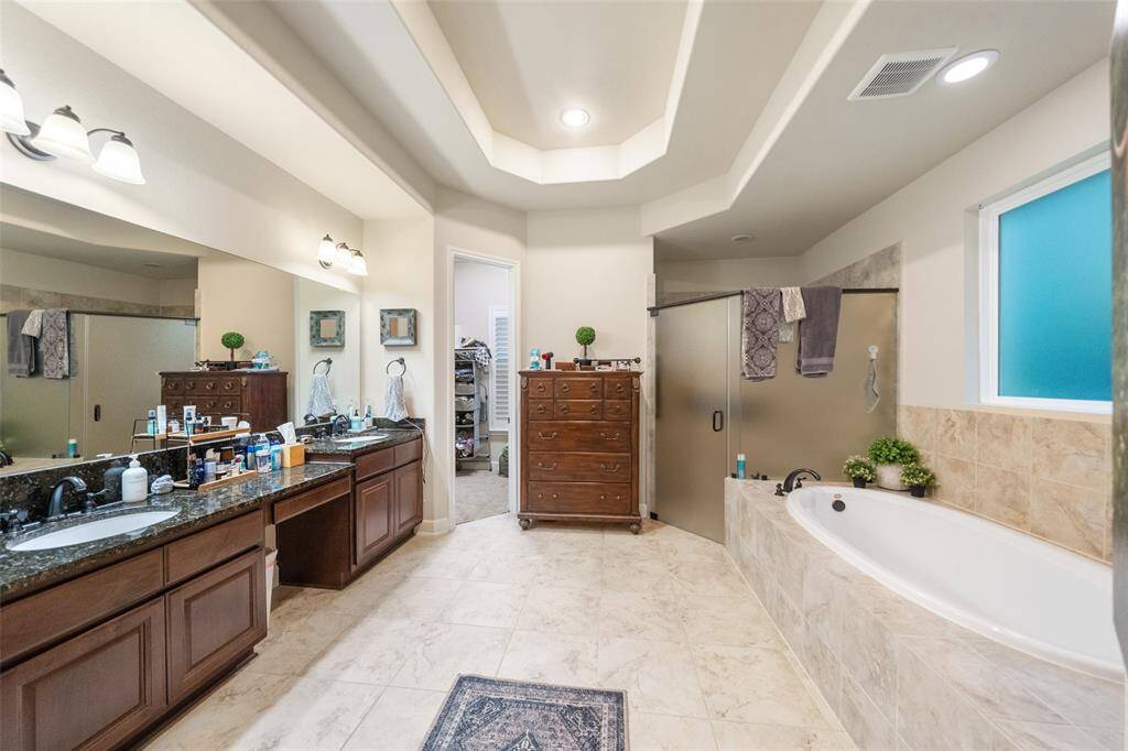 Step into your own private spa in this luxurious ensuite bath featuring a deep soaking tub, and oversized walk-in shower, and a dual sink vanity. With warm tones, soft lighting, and elegant finishes throughout, it’s the perfect place to unwind and indulge in a little daily luxury.