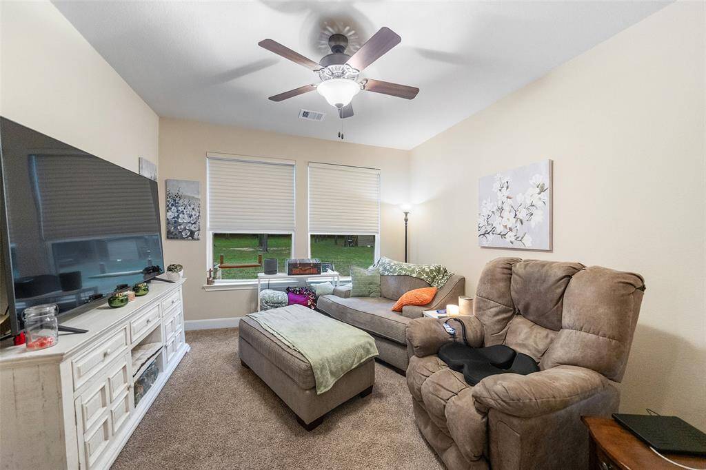 This roomy guest suite is currently set up as a casual hangout spot, but it’s perfect for overnight visitors too. With soft carpet, a ceiling fan, a large closet, and direct access to a full bath, it’s a comfortable space where everyone will feel right at home.