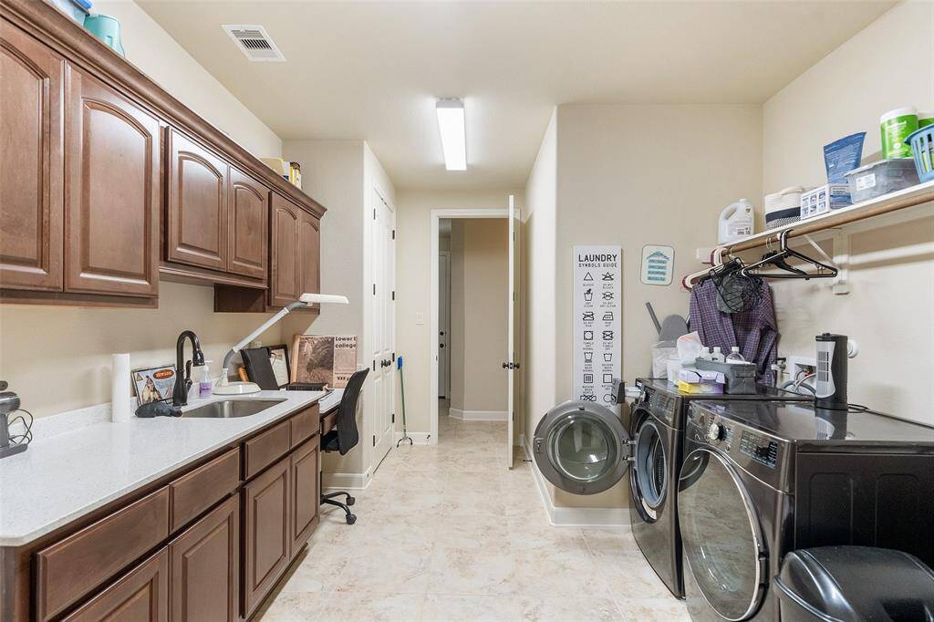 This extra-large utility room does more than laundry. With a closet, abundant cabinetry, a built-in sink, expansive folding counter, and a built-in desk, it’s perfect for crafting, sewing, or tackling everyday projects with ease.
