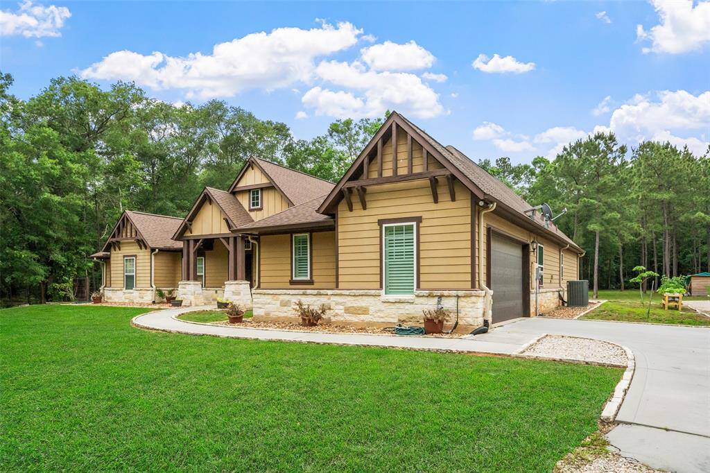 Surrounded by towering trees with a long private drive, this picture-perfect home makes a lasting first impression. Thoughtful landscaping, a welcoming front porch, and easy access to the 1,200 sq ft workshop create a peaceful, practical setup for everyday country living.