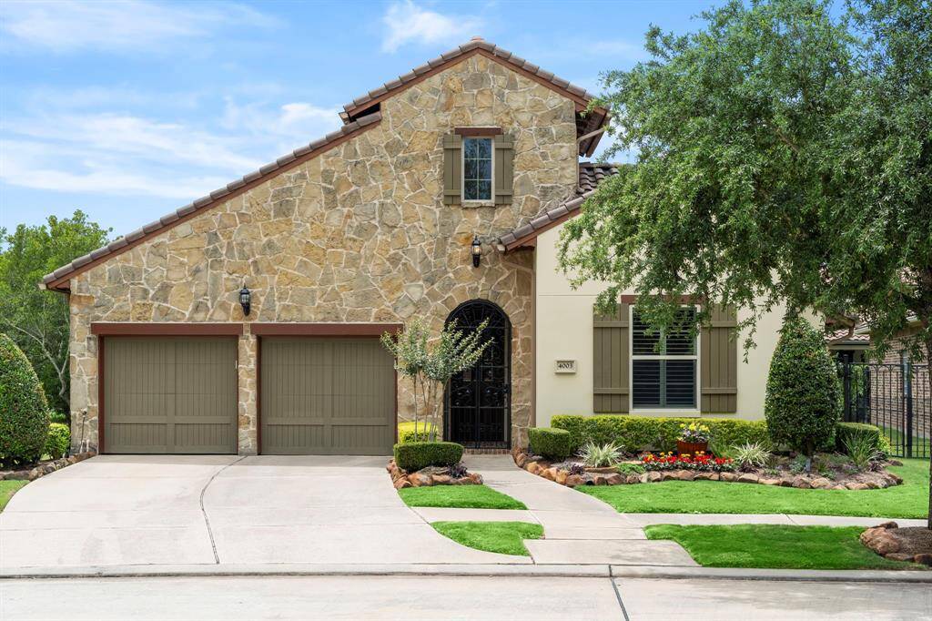 STUNNING Modern Spanish Style, brick and stone 1-story home in sought-after Kensington At Riverstone neighborhood blends traditional elements with contemporary influences to create a fresh and updated aesthetic.