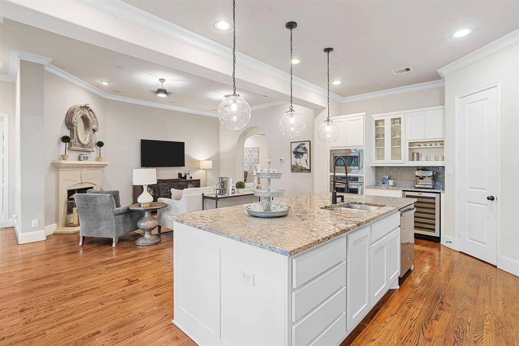 The large center island features a stylish breakfast bar, sleek granite countertops, and built-in storage, providing both a practical workspace and a beautiful focal point in the kitchen.