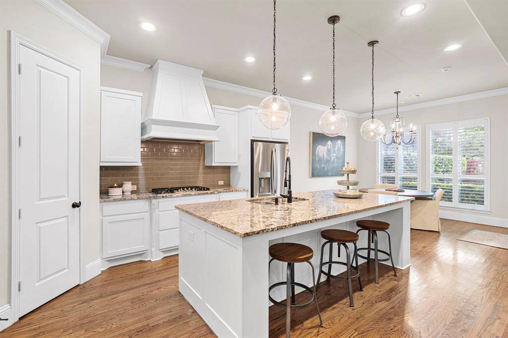Updated Visual Comfort daylight recessed lighting brightens the kitchen, breakfast area, dining room, living room, and foyer providing a clean modern aesthetic.