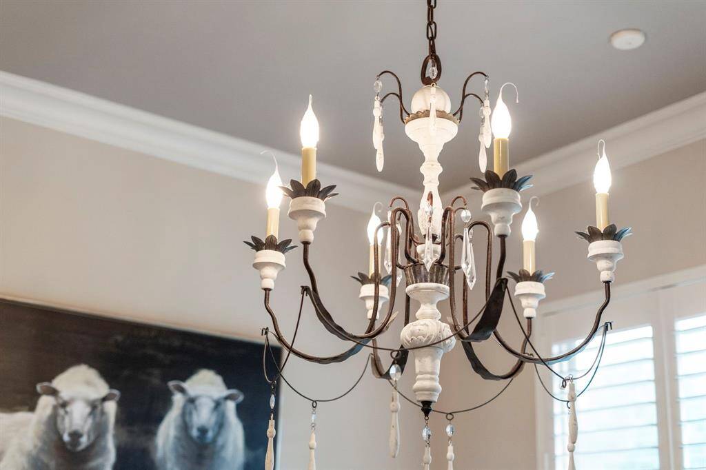 A striking French Country chandelier serves as a beautiful focal point in the breakfast area.
