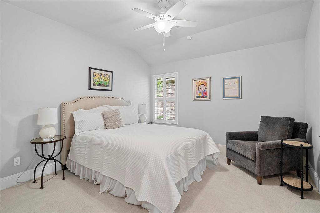 Vaulted ceilings add to the spaciousness of the secondary bedrooms. Bedrooms also feature low-profile neutral-toned carpet, walk-in closets with ample storage, and an en suite Hollywood bathroom.