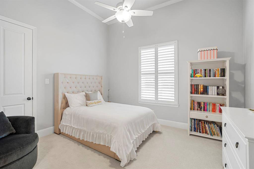 Large windows fill the secondary bedrooms with natural light, creating a bright and cheerful atmosphere, while classic plantation shutters offer privacy when desired.