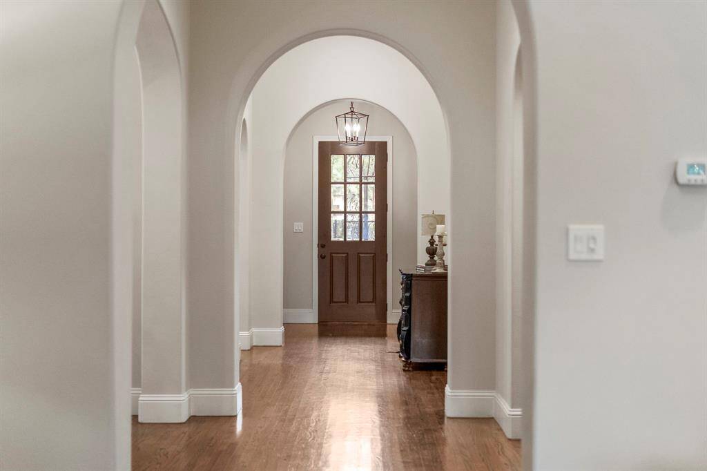 Arched hallways, a hallmark of Spanish Revival design, evoke old-world charm and craftsmanship, creating graceful transitions between rooms while reflecting the romantic, Mediterranean-inspired heritage of the home.