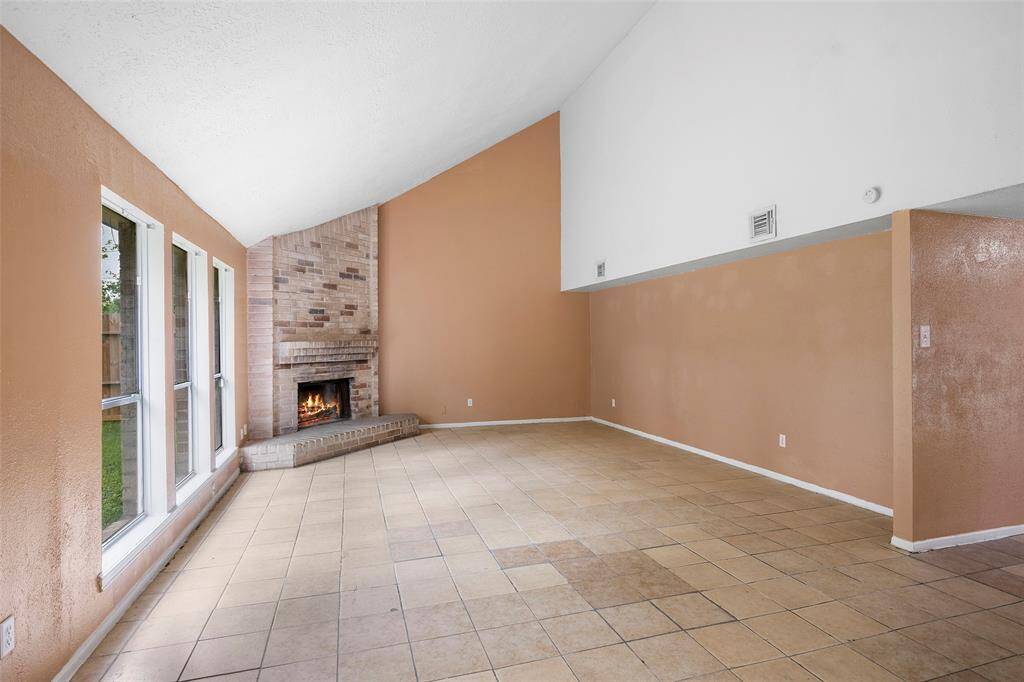 Step into the family room with large windows allowing natural light to flow through the space.  The corner stone fireplace adds cozy ambiance for a place to relax at the end of the day.