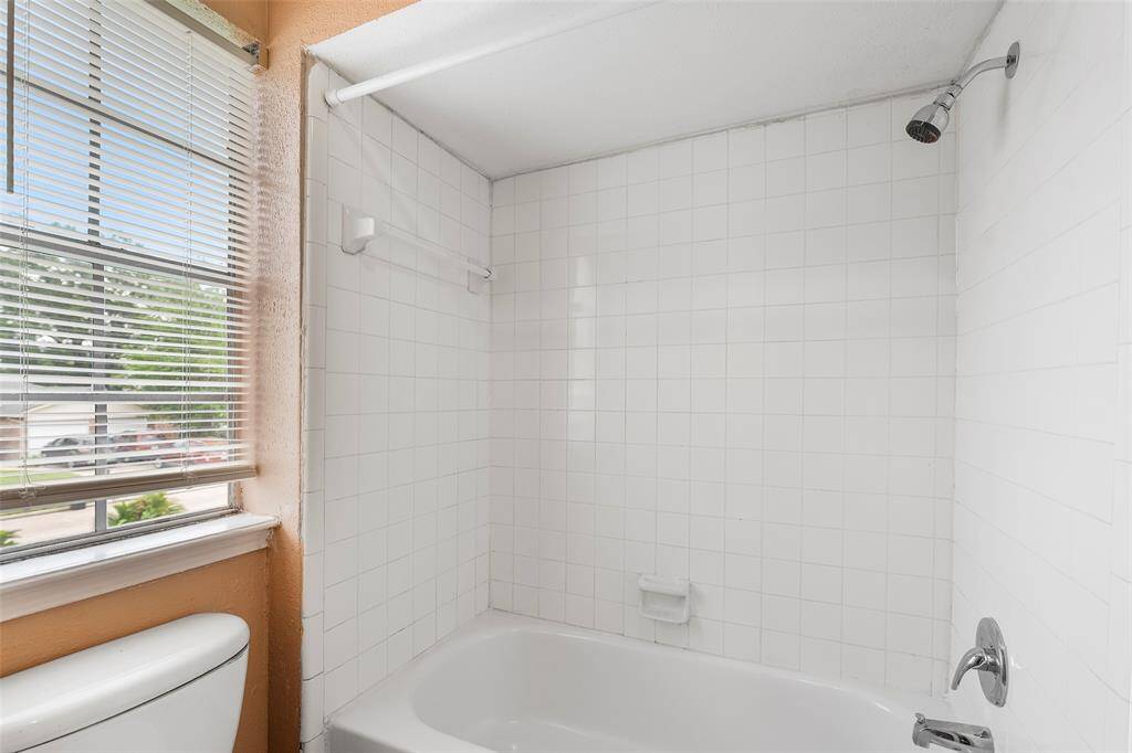 Bright white tile reflects light from the window and