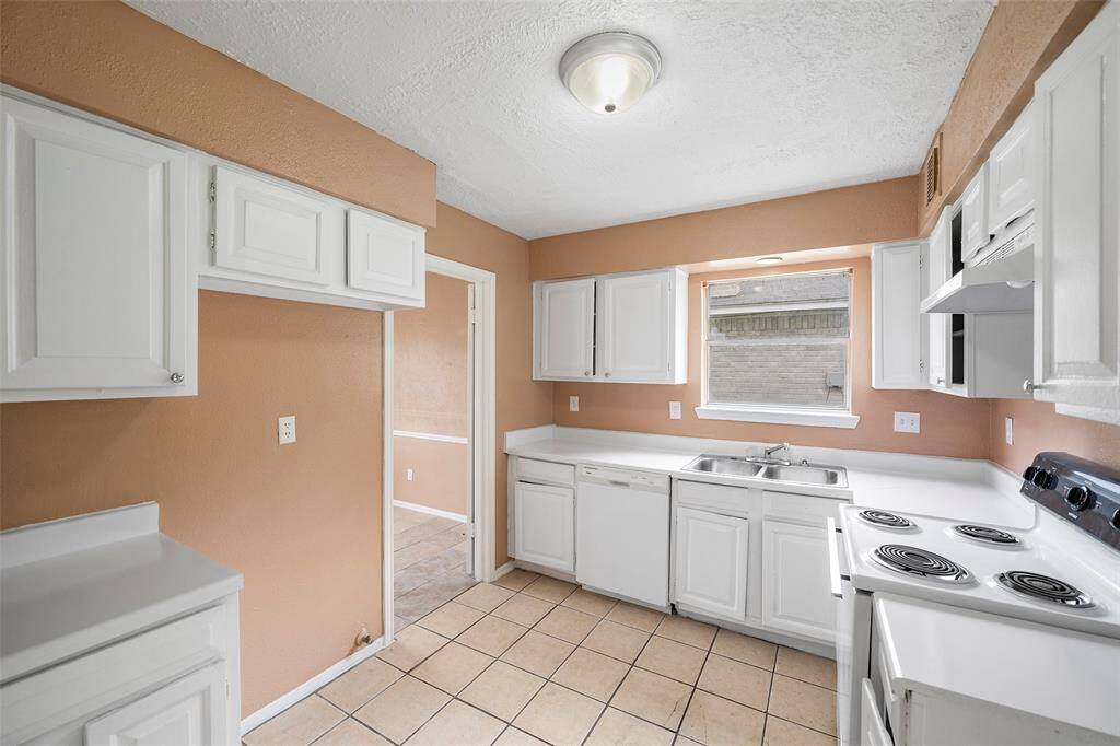 Crisp white cabinets and the window above the sink create a bright atmosphere.