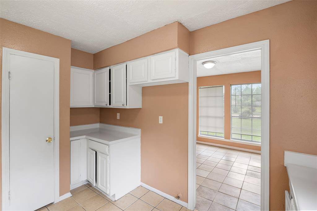 The kitchen wall has a dedicated spot for the refrigerator and right next to it, convenient counter space for unloading groceries.