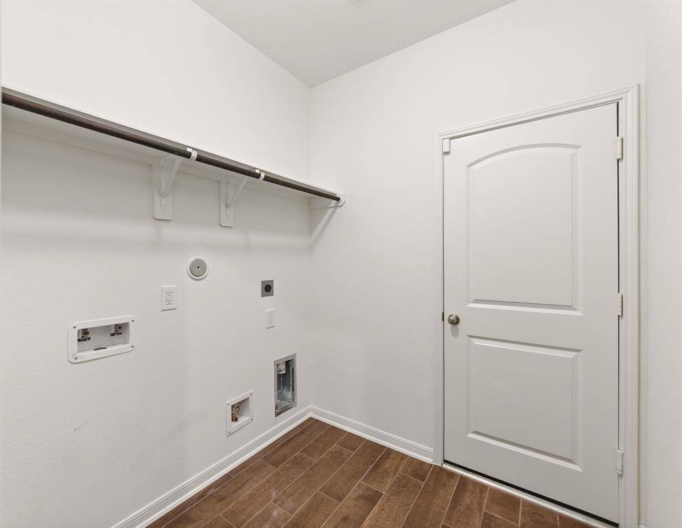 Spacious laundry room with modern hookups and ample shelving for storage