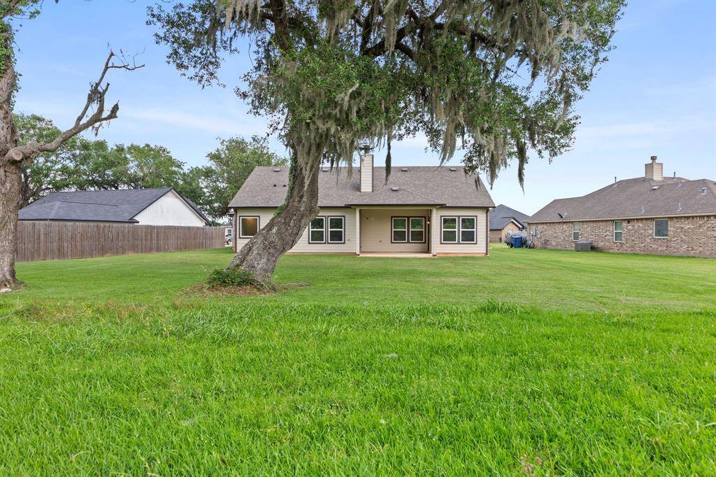 Enjoy a serene backyard with a majestic oak providing ample shade