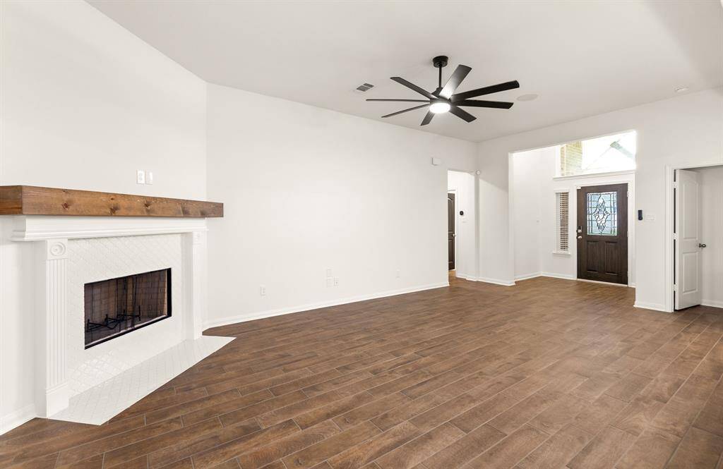 This open-concept living area features a stunning fireplace with a custom mantel, offering a warm and inviting ambiance