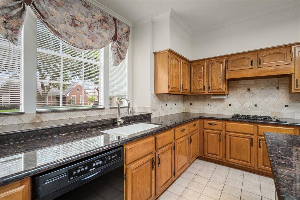 The kitchen's large window not only invites an abundance of natural light but also offers a serene view of the outdoors. Whether you're washing dishes or enjoying a quiet moment, this window frames a peaceful scene that enhances the kitchen's inviting atmosphere. The expansive view connects the interior to nature, adding a refreshing touch to this already warm and functional space.