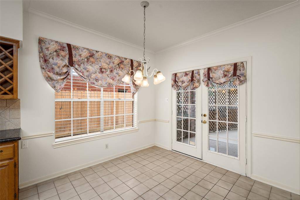 The breakfast area offers a warm and inviting space, featuring a wide window on the left that brings in an abundance of natural light. French doors directly in front open up to the backyard, creating a seamless transition to outdoor living. This area is perfect for enjoying casual meals or a quiet moment, with a bright, airy atmosphere that connects the home to its outdoor surroundings. Whether you're enjoying breakfast or relaxing, this space offers comfort and convenience with a picturesque view.