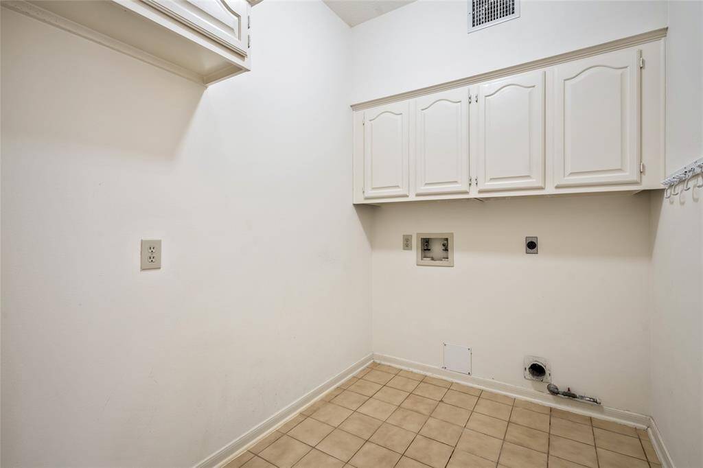 This laundry room is efficiently designed with just enough space to accommodate a washer and dryer, providing a practical and functional area for your laundry needs. Simple cabinetry offers storage for essentials, while the neutral tones keep the room bright and tidy. It's a convenient and well-organized space, making laundry day easier without taking up too much room.