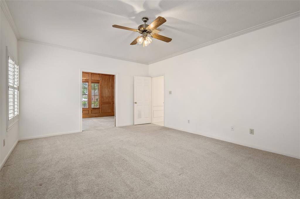 This versatile adjoining room features soft, plush carpeting and walls painted in a fresh, neutral tone—perfect as a second office, sitting room, or guest space. Plantation shutters on the windows provide privacy while allowing natural light to filter in beautifully.