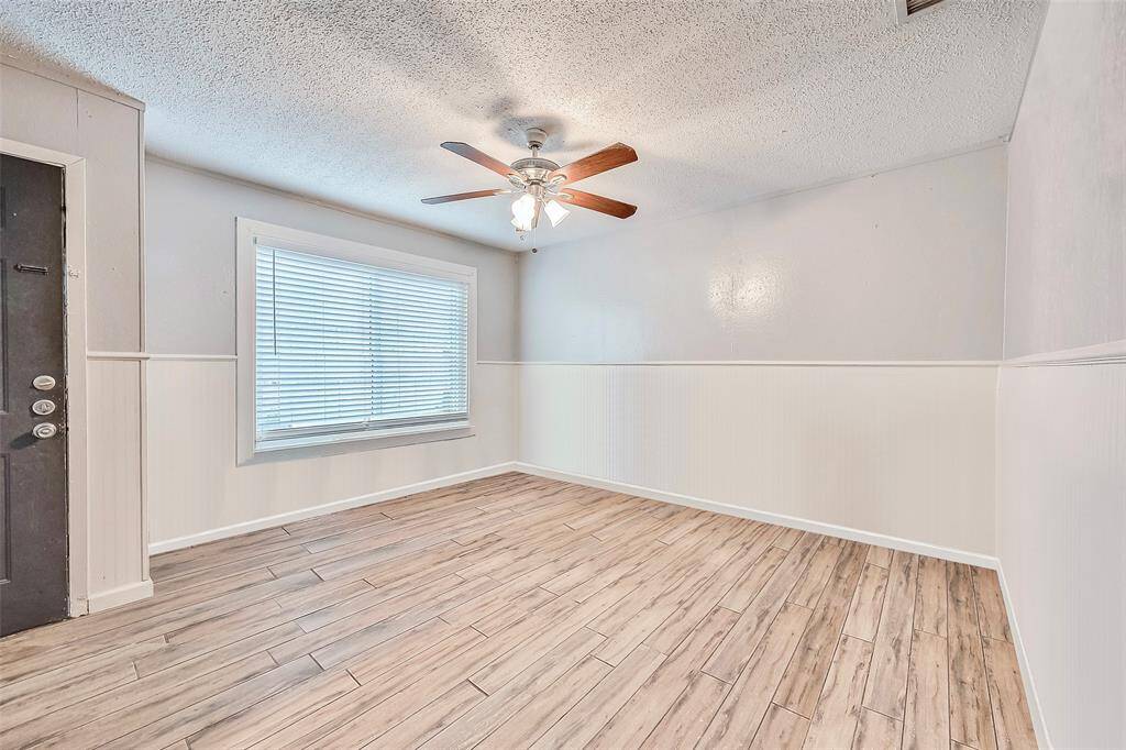 Spacious living room features a ceiling fan