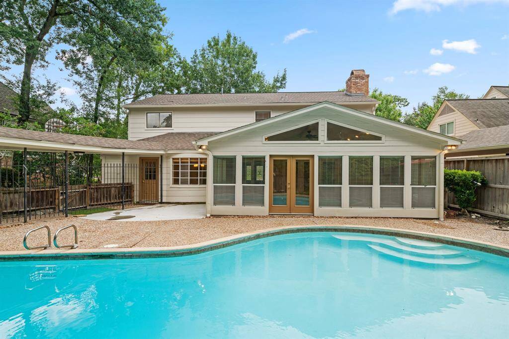 Sparkling pool with recent concrete patio and large decks for outdoor entertainment. This view shows the game room.