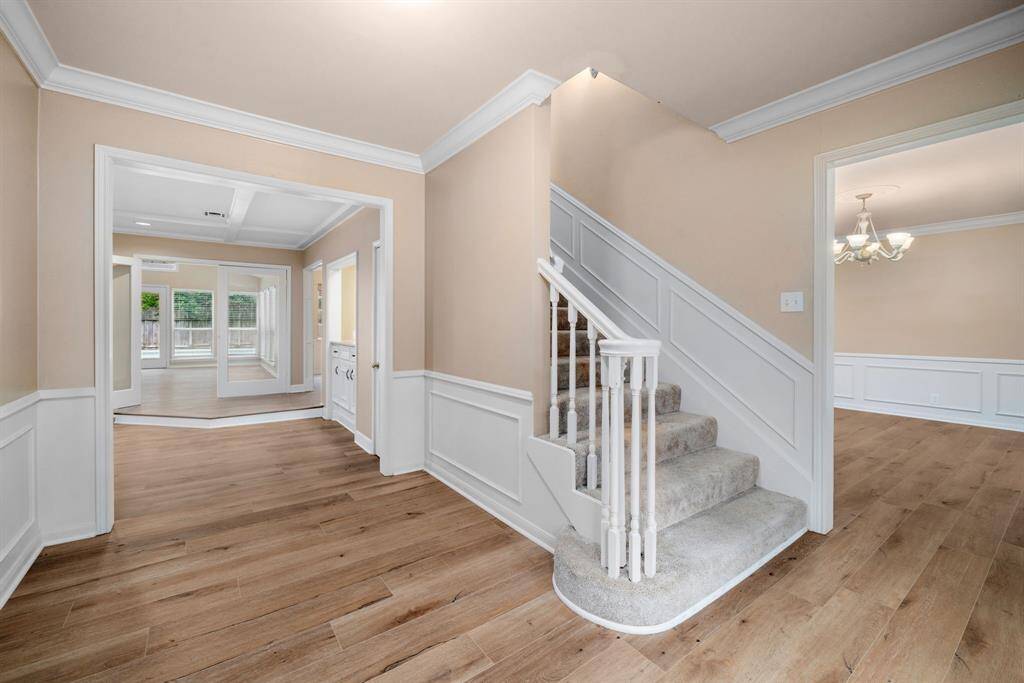 View of flow: formals on either side of entry with large family room in view. Over-size den in rear overlooks pool.