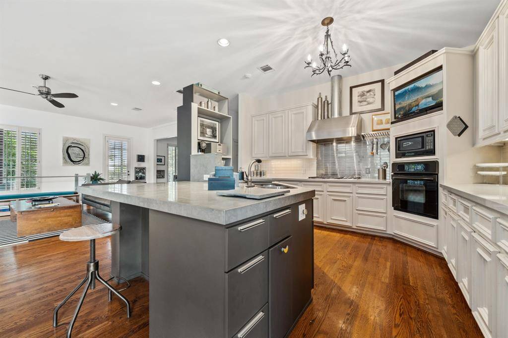 This well-appointed chef's kitchen is a true culinary haven, featuring top-tier appliances, ample counter space, and sleek finishes. Open to the living and dining areas, it’s designed for both everyday meals and entertaining, making it easy to engage with family or guests while preparing delicious dishes.