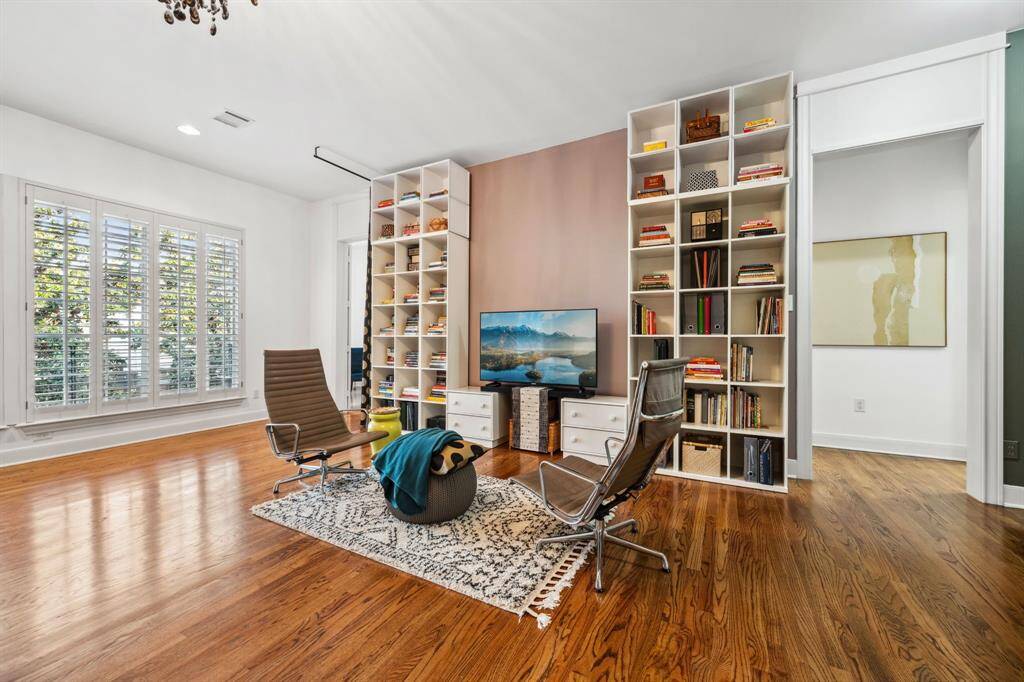 This bright and airy primary bedroom features gleaming oak floors and a cozy sitting area, providing the perfect space to relax and unwind.