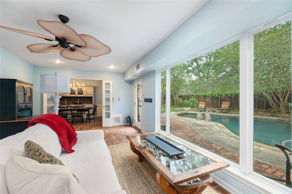 This serene sitting room offers stunning views of the backyard pool, creating a relaxing space filled with natural light. A perfect spot to unwind while enjoying the tranquil outdoor scenery.