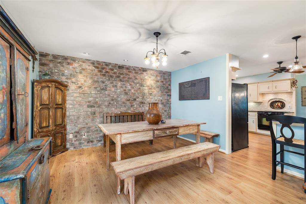 A charming breakfast nook just off the kitchen features an exposed brick wall that adds warmth and character. The space is further enhanced by charming light fixtures, creating a cozy spot to enjoy casual meals and morning coffee.