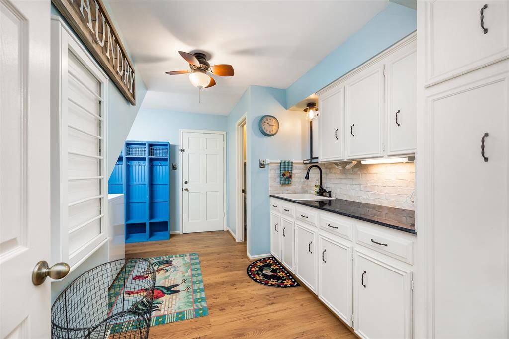 This expansive laundry room offers generous storage, a convenient sink, and plenty of counter space for all your needs. The design continues seamlessly from the kitchen, maintaining the same attention to detail and functionality, making laundry chores a breeze.