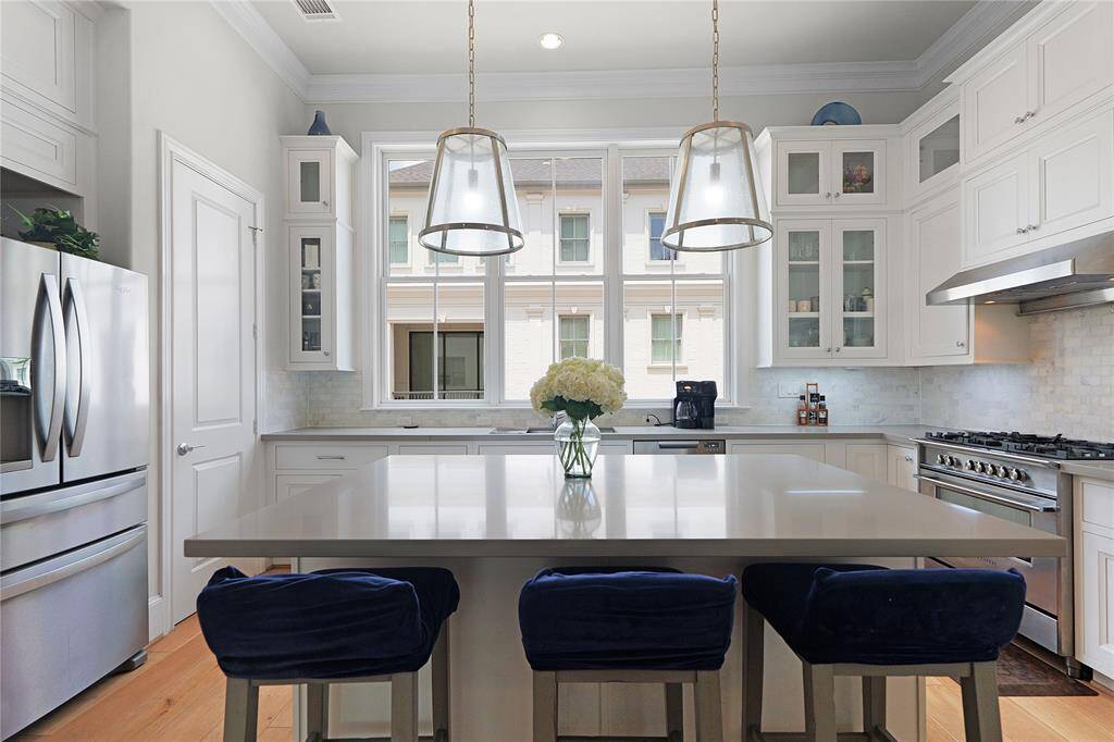 Outfitted with a premium Fisher & Paykel appliance package, the kitchen also features soft-close drawers, under-cabinet lighting, and elegant hardware add refined touches, while the open-concept layout keeps the space bright and connected to the adjacent living and dining areas.